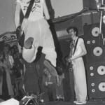 Zoomed in image of DEVO, JANUARY 6, 1978, 27 PUNK PHOTOS, #27 which shows one of the members of DEVO jumping up and playing guitar