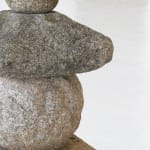 Round body of stone sculpture with sloped top.