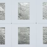 Detail; 3x2 grid of rectangular foil slides, each with unique raised linear designs, in white mounts.