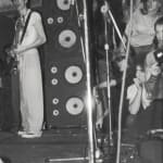 Zoomed in image of DEVO, JANUARY 6, 1978, 27 PUNK PHOTOS, #27 which shows one of the members of the band standing while playing guitar