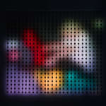 Still image of Home Movies Pause (David) with multi-colored blurred blobs shining onto the wall from the LEDs