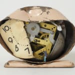 A small figurine stands inside of a crushed and rusted baby pink clock