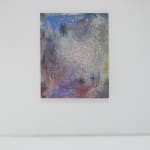 A multicolored abstract painting hangs on a white wall.