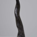 Strands of the artist’s hair tightly compacted and glued together to form a sculpture resembling a large black curving horn. Due to the nature of the binding agent the sculpture appears to be made out of polished stone or marble rather than hair