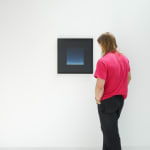 A white man admires framed Floating Phthalo Blue Square hanging on a white wall