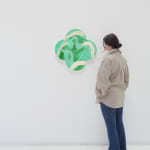 Wide installation view of Island Treasure with woman to the right of the piece to show scale