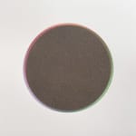 Rainbow colored ring surrounds the perimeter of a brown circle made of tiny dots against white background.