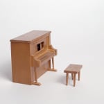 Still from video; wood piano and bench figurines