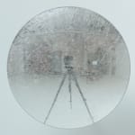 Front view of engravings on a clear disk, with reflection of tripod.