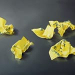Five crumpled yellow Post-it notes with blue cursive writing against gray background.