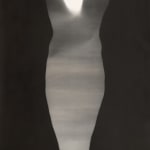 Black and white photograph whose edges have been blacked out to allow the remaining negative space to take the form of a body At the top of the piece two hands directly above and below each other appear to be glowing and pressing against the surface of the work from within