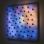 An image of scattered black pegs with a colorful background.