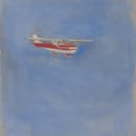 Red and white Cessna plane flies to the right against blue sky and exposed canvas background.