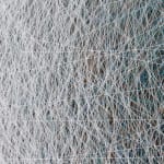 Detail: hundreds of overlapping, multicolored threads, primarily white.