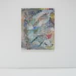 A multicolored abstract painting hangs on a white wall.