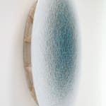 Side view of a blue ombre circle created from overlapping threads.