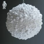 White large moon and small astronaut sculptures made from casts of the artist’s body parts. The moon is made up from the various sized casts of the artist’s lips while the floating astronaut figure is made up of thumbs fingers and toes