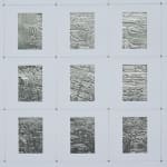 Detail; 5x3 grid of rectangular foil slides, each with unique raised linear designs, in white mounts.