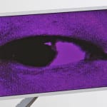 Detail of the LCD screen in Creature II with the purple colored eye looking to the left