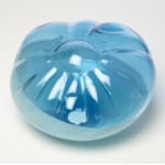 Top view of a cushion-like blown-glass sculpture, top two-thirds translucent blue, bottom one-third opaque blue.