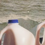 Tops of two gallon milk jugs on foggy beach.