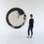Installation of Enso-afterJuin with woman to the right of the piece to show scale