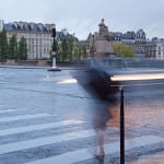 Two faint figures crossing in crosswalk in rainy Paris.