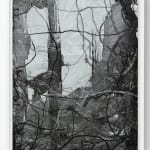 Dark gray vertical flat brushstrokes with overlapping ink trails that crawl across the paper with a heavier concentration of ink in the lower right corner. The work is contained in a white wooden frame.