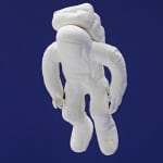 Detail view of astronaut figure composed of casts of fingers.