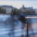 Faint figures crossing in crosswalk in rainy Paris.
