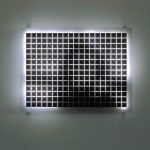 Still image of a rectangular piece with multiple white LEDs behind Plexiglass with grid of black squares on its surface that displays blurred scenes taken from old family home movies