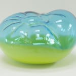 A cushion-like blown-glass sculpture, top 2/3 translucent blue, bottom 1/3 opaque yellow.