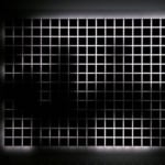 Still image of a rectangular piece with multiple white LEDs behind a thick block of acrylic which has a grid of black squares on its surface The LEDs display blurred street scenes