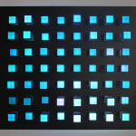 An image of little square pegs in a black panel of exploded random colors