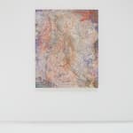 A multicolored abstract painting of fibrous strands hangs on a white wall.