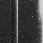 Detail of speckled black strip with gradient o lighter color on edge on speckled black paper.