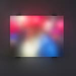 Still image of multiple multi-colored LEDs blurred behind thick block of resin show people walking through a crowd in the twenty seventeen Women’s March in Washington DC