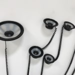 detail view displaying grey and black speakers with black coiled wires.