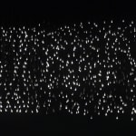 A detailed shot of light bulbs of people walking.