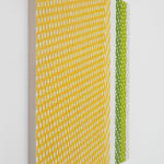 Side view of a yellow, white, green and grey abstract painting mimicking fabric.