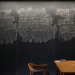 Wall sized chalkboard with erasures and formulas by professor Noga Alon, with wooden chair and desk in front, from the Do Not Erase series by Jessica Wynne