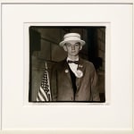 Diane Arbus portrait of young white man in straw hat, waiting to march in a pro-war parade in NYC, holding an American flag, with Bomb Hanoi and Support Our Troops pins