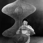 Imogen Cunningham, Ruth Asawa Kneeling Behind a Hanging Looped-Wire Sculpture, 1957
