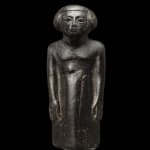 Egyptian, An Egyptian black stone figure of an official, Kumes, Middle Kingdom to Second Intermediate Period, circa 2055 - 1550...
