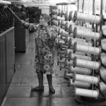 Homer Sykes, Factory work, woman working in Salts Mill Saltaire Yorkshire, 1981