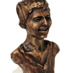 A miniature bronze bust of Carina, approximately 13 cm tall, featuring her with short, textured hair and a gentle smile. The bust emphasizes a warm and expressive sculpting style, capturing her personality with a simplified yet detailed approach.