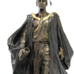 A bronze statue of a male graduate at Macquarie University, depicted walking confidently forward, wearing academic robes, a mortarboard, and holding a rolled-up diploma. His expression is determined, symbolizing achievement and progress.
