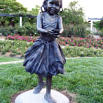 Bronze sculpture of a young girl holding out her hands holding a flower, in a gesture of offering, created as part of the Expressions of Love series at Hunter Valley Gardens.