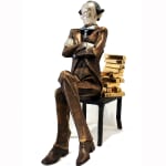 A large sculpture of a banker seated on a chair with a backrest made of stacked gold bullion. The figure, dressed in a formal suit with arms crossed, has a polished, reflective face that adds a surreal element to the piece. One chair leg is visibly bending under the weight of the gold, symbolizing the burden of wealth.
