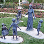 Outdoor bronze sculpture series featuring children and a grandmother interacting in various playful and loving poses at Hunter Valley Gardens
